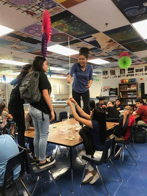 Students work together to build tall towers. 