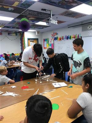 Students work together to build tall towers. 